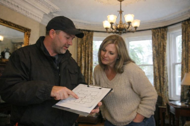 an illustrative image of a professional discussing plans with a homeowner win a Victorian home