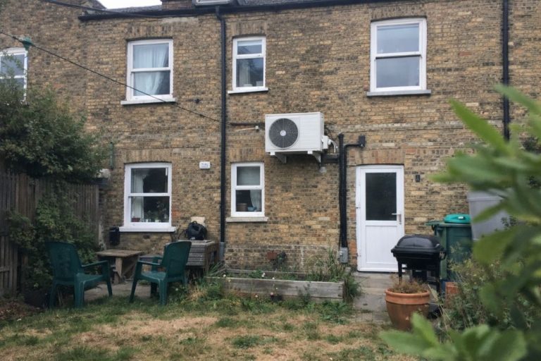 an illustrative image of a residential property with an outdoor AC unit mounted