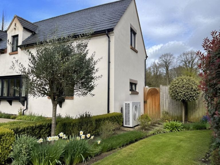 an illustrative image of a modern UK family house with a discreet air conditioning outdoor unit visible at the side