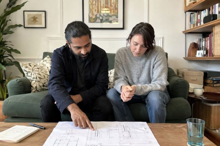 an illustrative image of a system designer consulting with a homeowner in the living room of a Victorian London terrace